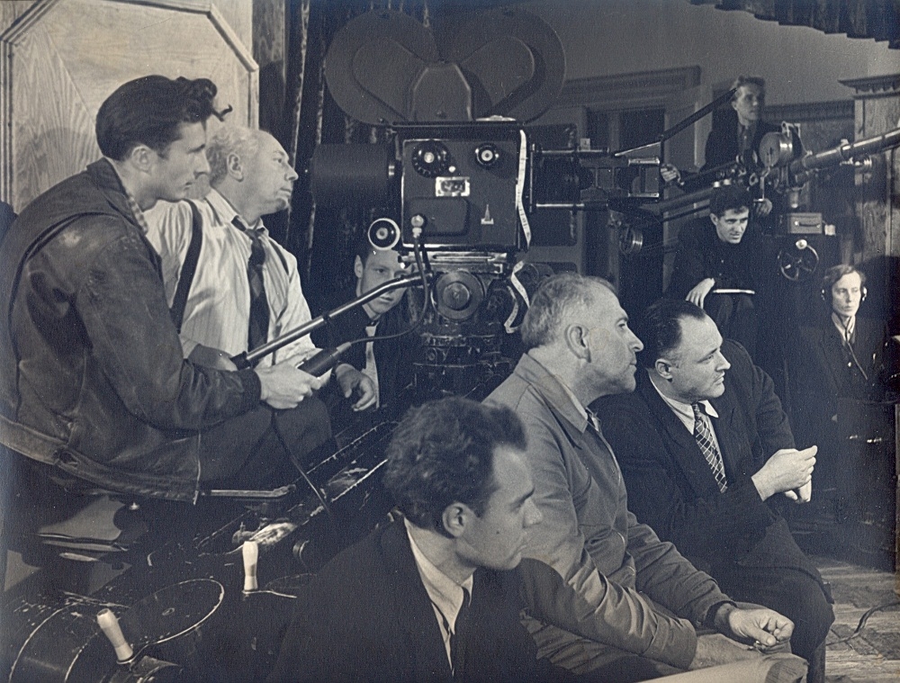1956. gads, filmas "Pēc vētras" uzņemšana. No kreisās – operators-praktikants Zigurds Vītols, galvenais operators Jūlijs Fogelmans, otrais operators Māris Rudzītis, priekšplānā no kreisās - otrais režisors Varis Krūmiņš, galvenais režisors Eduards Penclins, režisors Aleksandrs Leimanis.